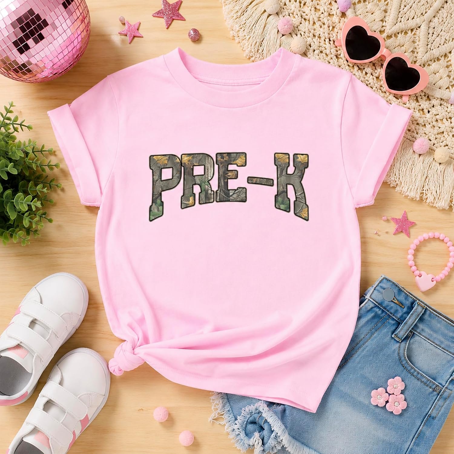 Flat lay of Pre-K camo shirt showing natural fabric and screen-printed camo graphic