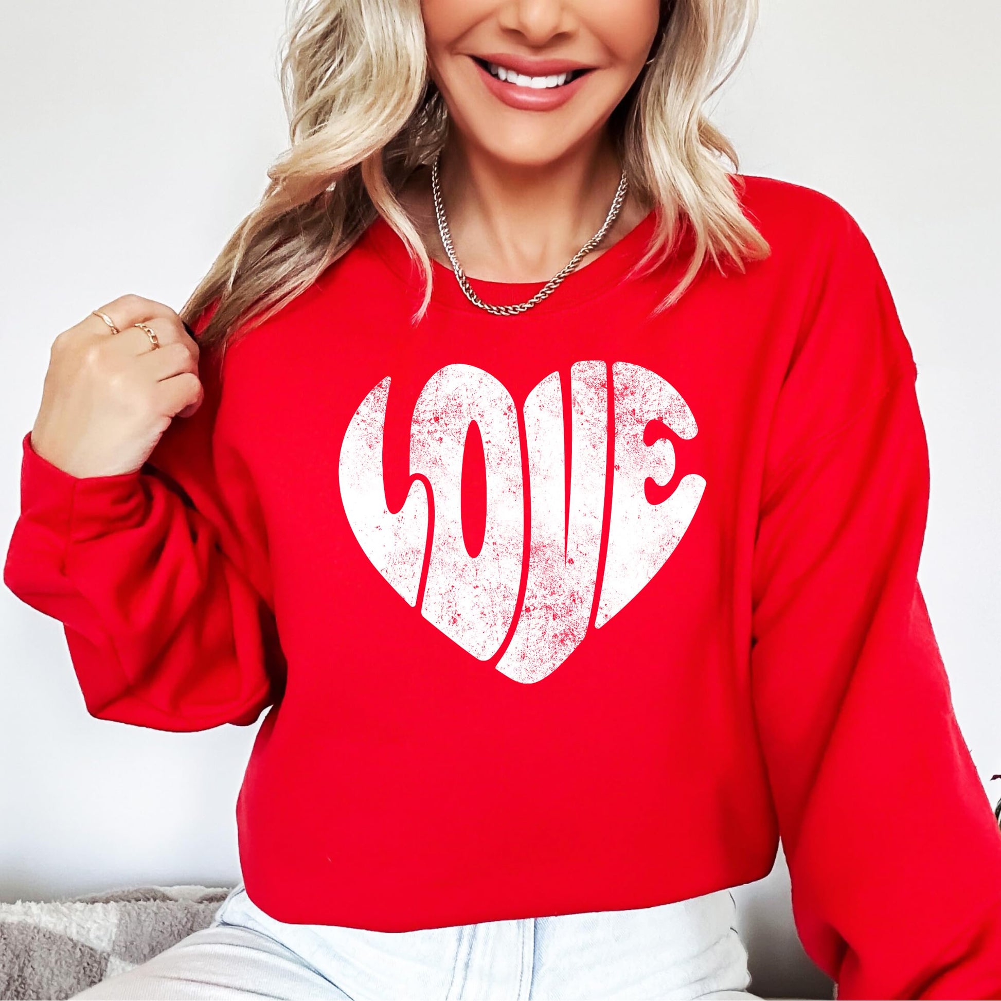 Women's red Valentine's Day sweatshirt with vintage heart design, styled flat lay