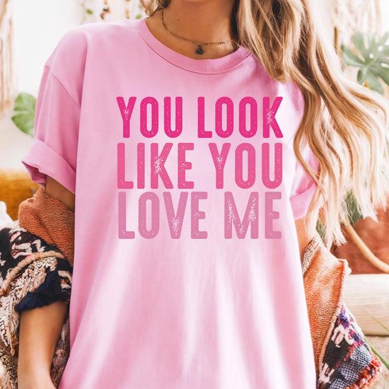 Side angle of black women's tee featuring You Look Like You Love Me pink text