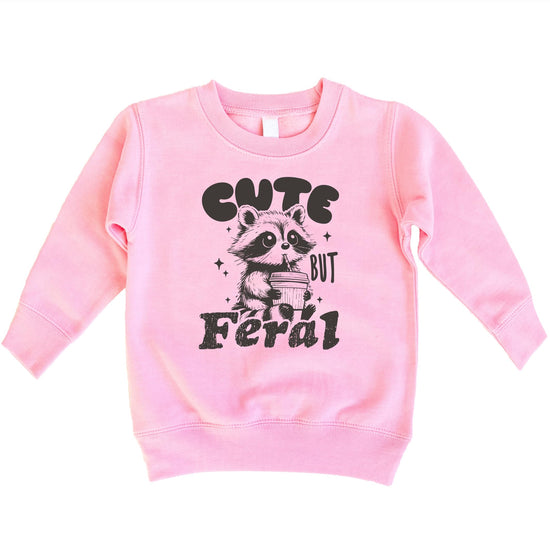 Close-up of the Cute But Feral raccoon cocoa design printed on a kids sweatshirt