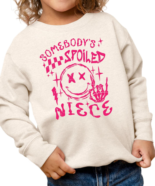 Front view of Somebody's Spoiled Niece kids sweatshirt in pink with bold alternative-style graphic print
