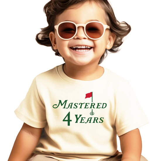 Close-up of Mastered 4 Years golf birthday graphic on natural kids t-shirt