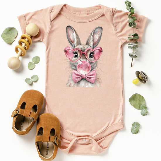 Detail shot of Easter rabbit with pink glasses and bow graphic on baby girl one-piece bodysuit