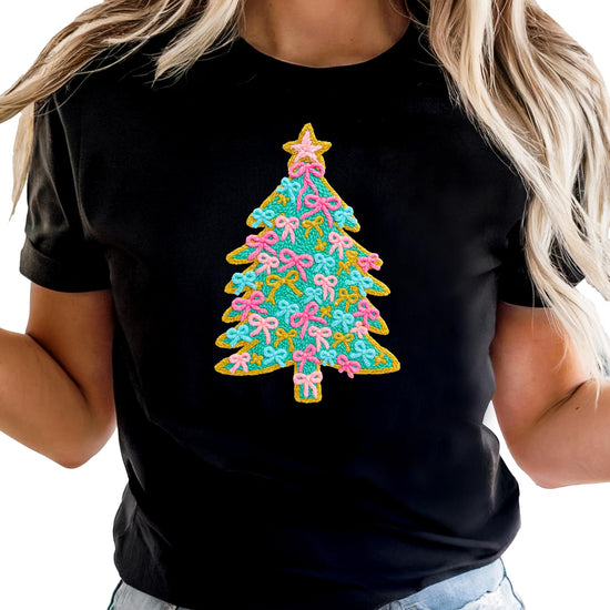 Side angle view of kids holiday graphic shirt with Christmas tree, pink bows, and gold star topper