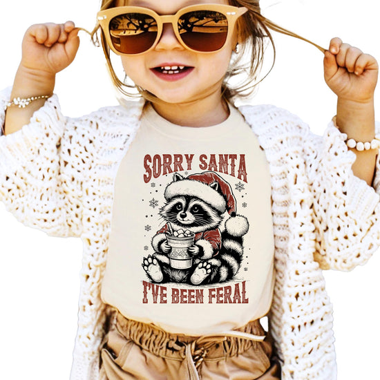 Kids version of Sorry Santa I've Been Feral funny holiday tee with raccoon Santa design
