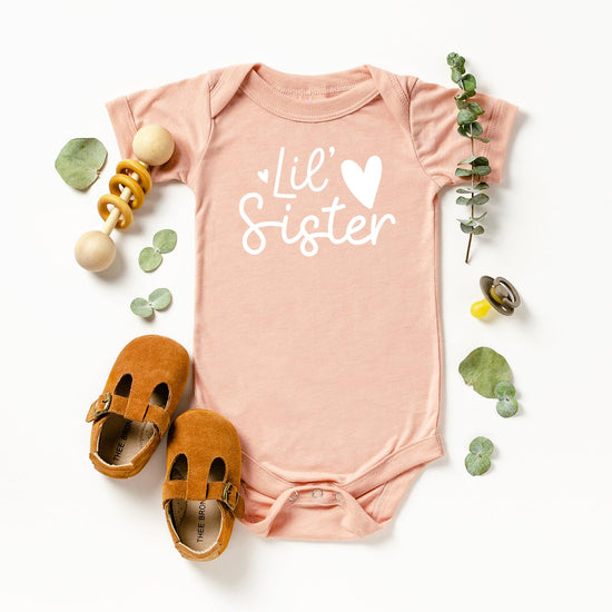 Flat lay of mauve Lil Sister Heart Bodysuit for newborn girls