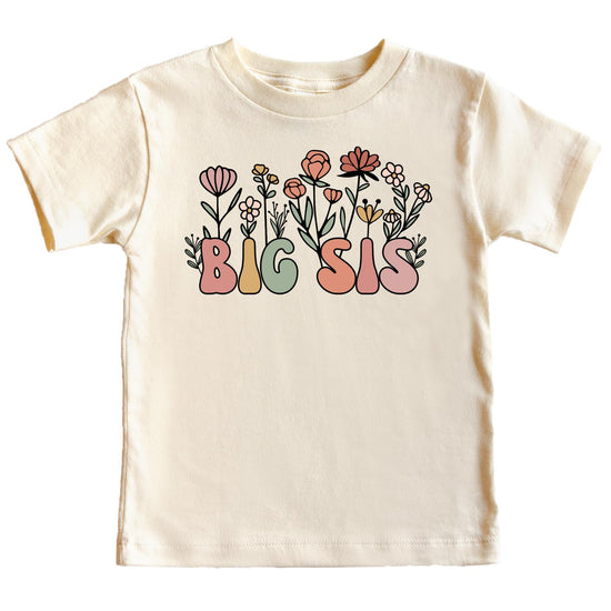 Toddler girl wearing a natural color floral big sister graphic tee with colorful lettering
