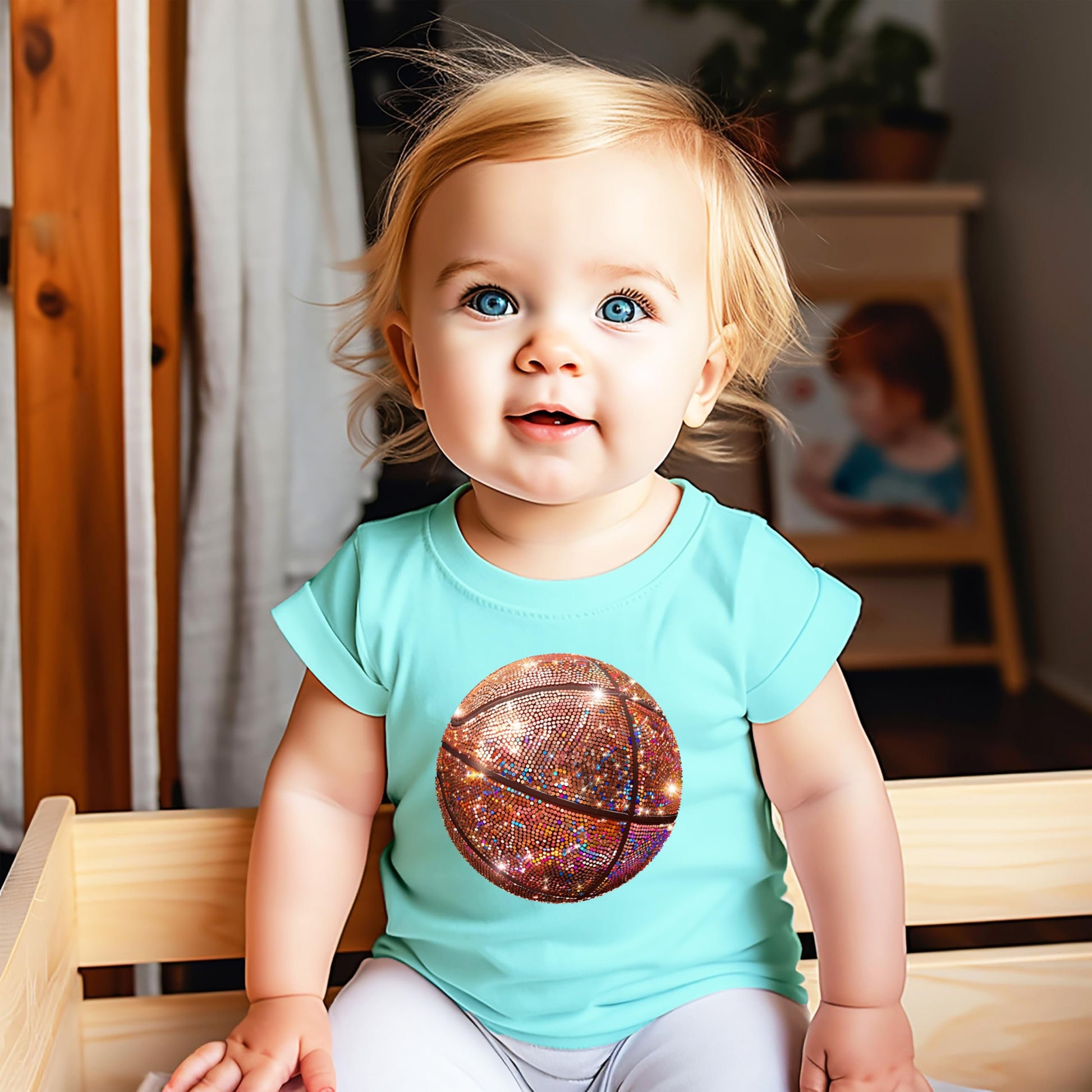 Detail shot of high-quality faux glitter basketball print on pink kids graphic tee