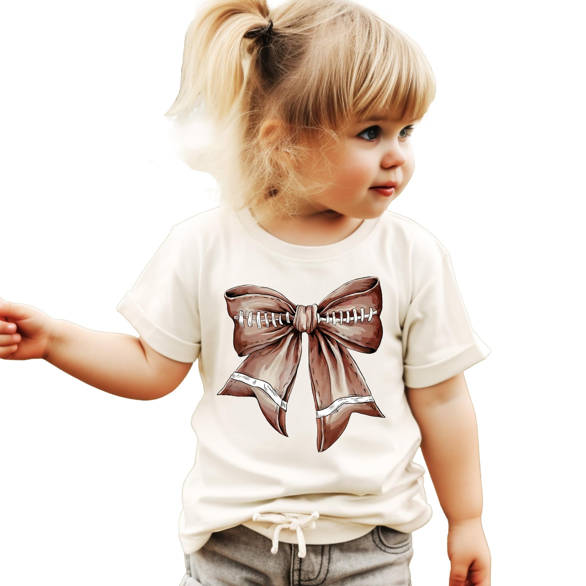 Close-up of football bow graphic on a natural kids tee showing vibrant print quality
