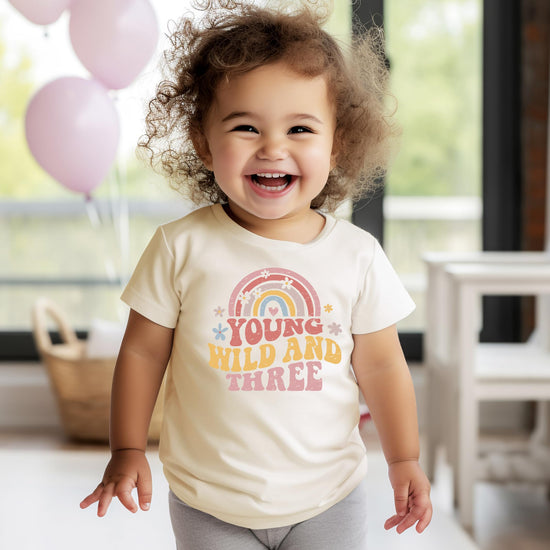 Detail shot of retro rainbow lettering on Young Wild Three birthday tee
