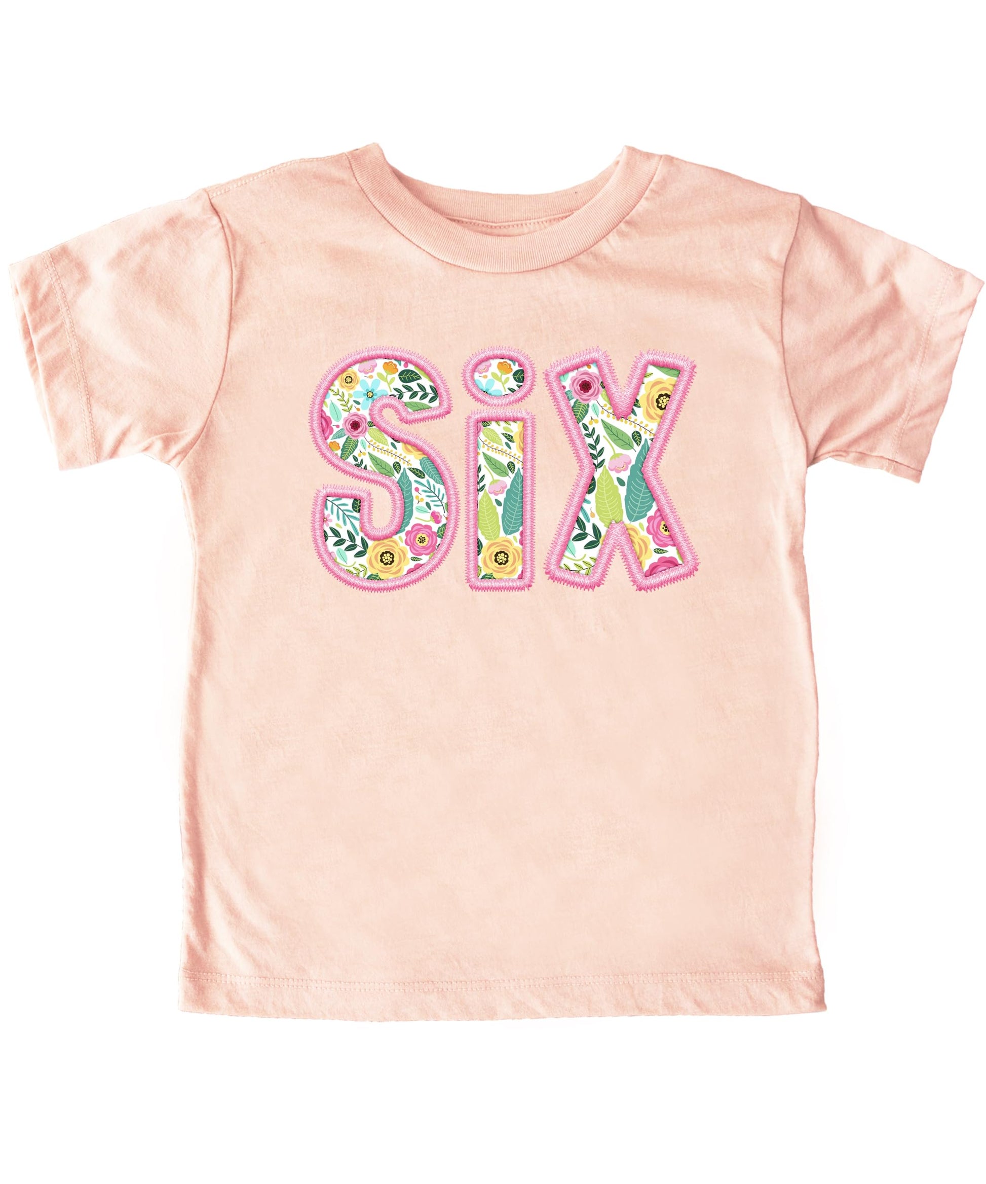 Close-up of floral SIX graphic on peach girls birthday shirt with pink embroidered-style lettering