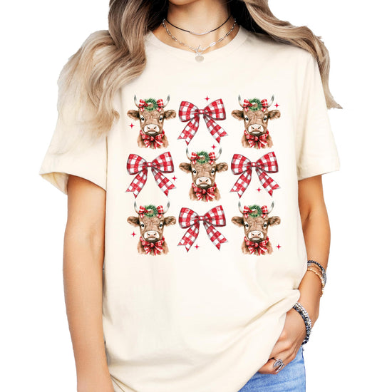 Youth girls wearing Christmas cow and plaid holiday bow graphic tee in peach