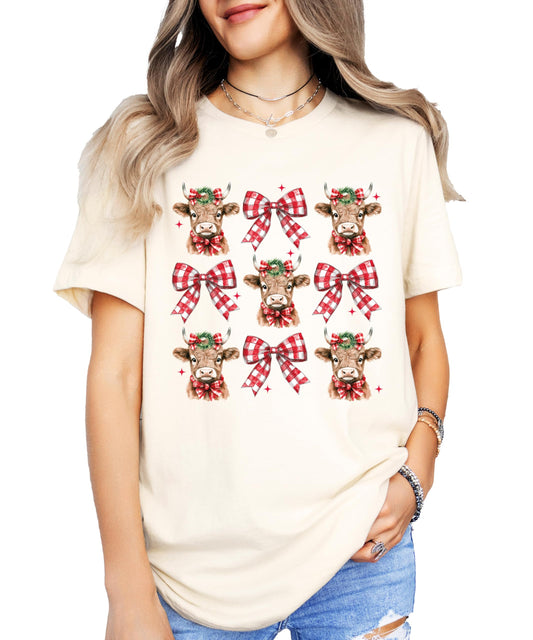 Youth girls wearing Christmas cow and plaid holiday bow graphic tee in peach
