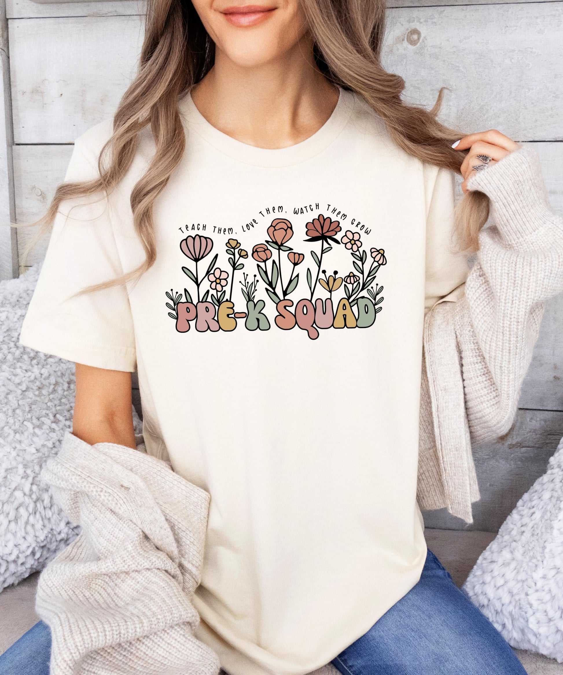 Flat lay of Pre-K Squad floral teacher shirt showing full design and peach color