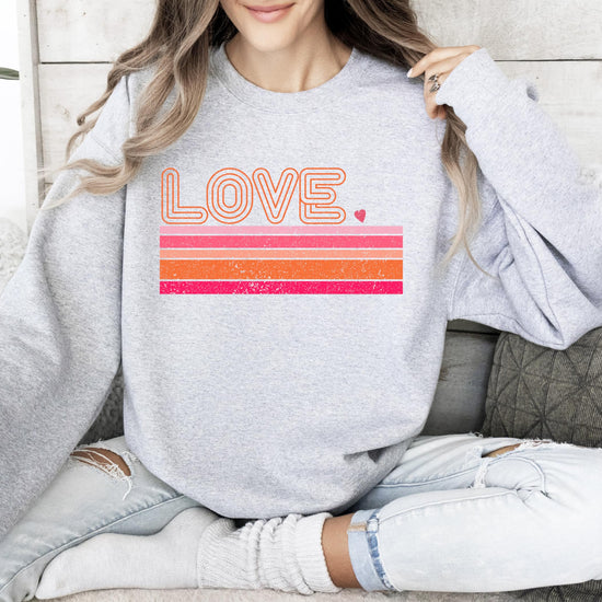 Flat lay of gray Valentine's Day sweatshirt featuring retro Love graphic by Olive Loves Apple