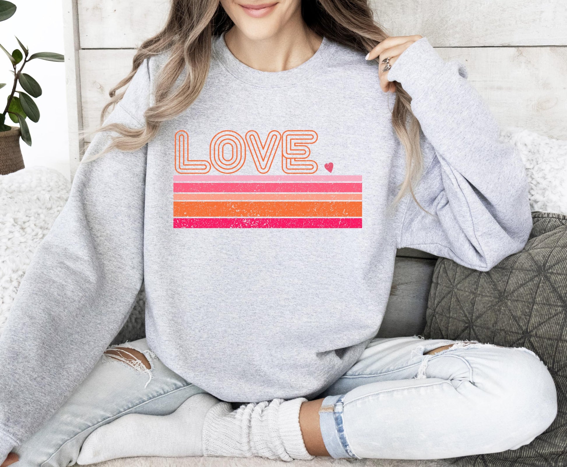 Flat lay of gray Valentine's Day sweatshirt featuring retro Love graphic by Olive Loves Apple