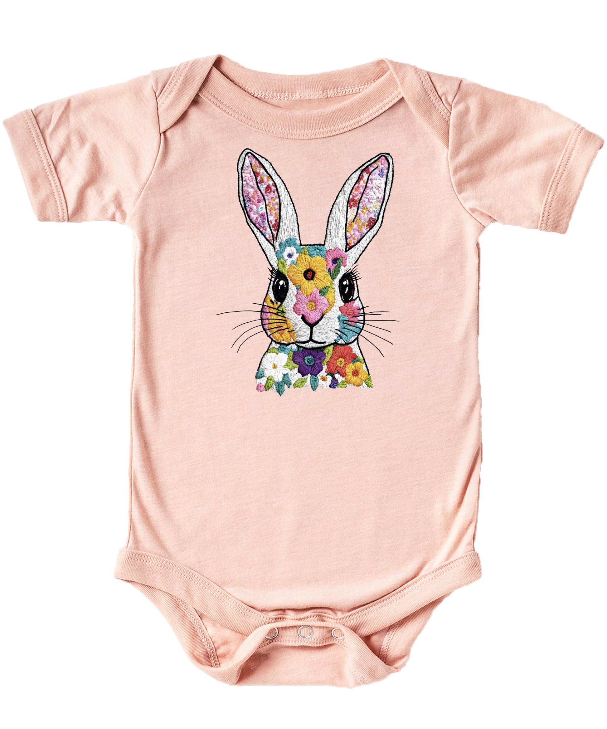 Close-up of floral rabbit ink print on a soft peach baby onesie