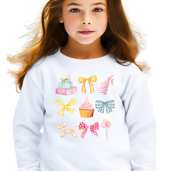 Kids birthday sweatshirt flat lay showing full pastel coquette graphic with presents and party hats