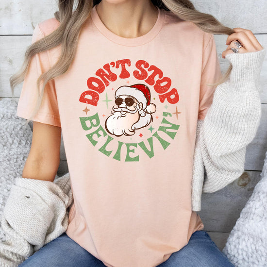 Flat lay of women's natural Christmas graphic tee with Santa holiday design