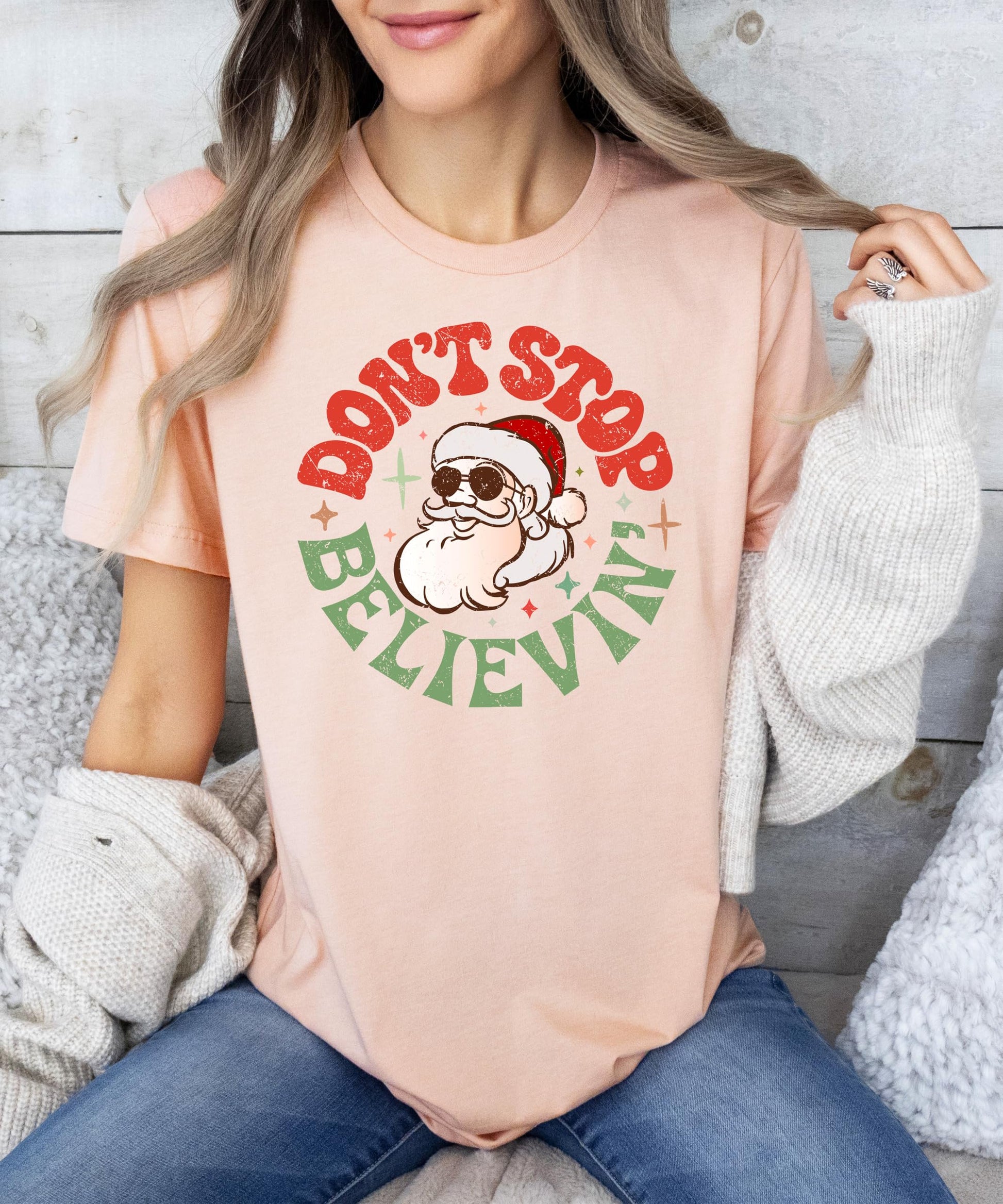 Flat lay of women's natural Christmas graphic tee with Santa holiday design