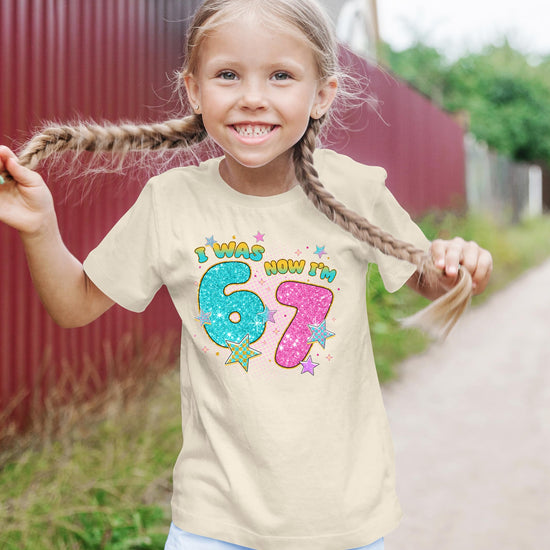 Flat lay of pink girls' birthday shirt with glitter number 7 graphic