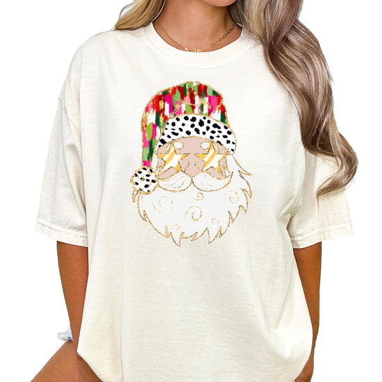 Side view of women's casual fit ivory holiday tee with humorous gold sunglasses Santa graphic