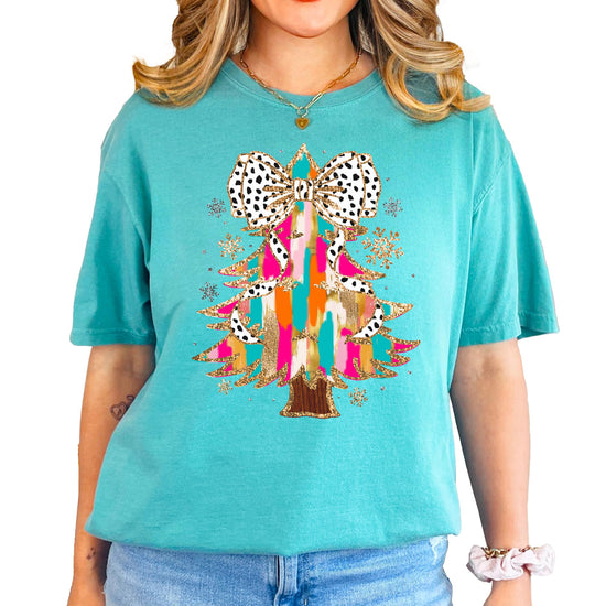 Detail shot of dalmatian dot coquette bow topping the glitter Christmas tree on women's tee