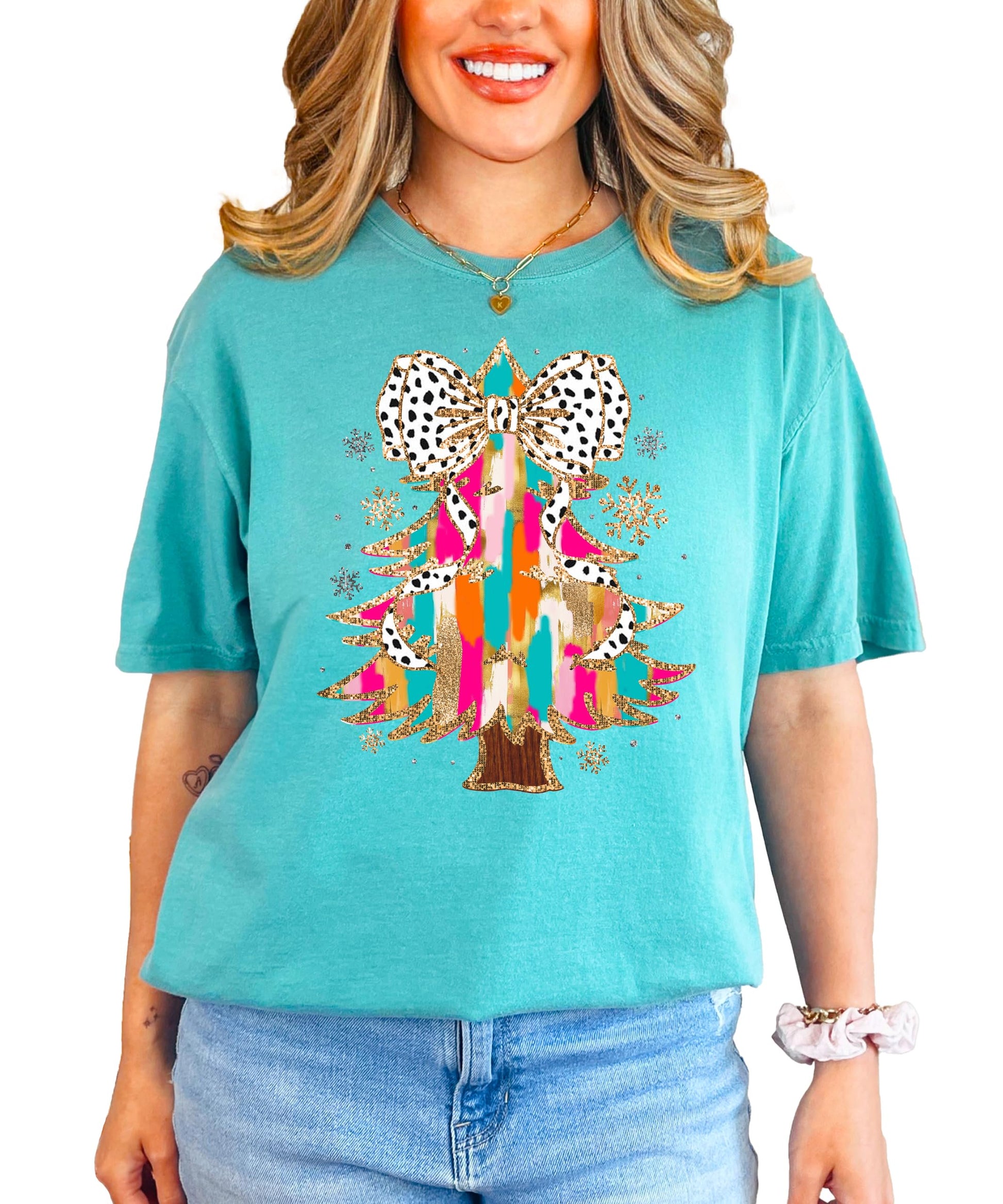 Detail shot of dalmatian dot coquette bow topping the glitter Christmas tree on women's tee