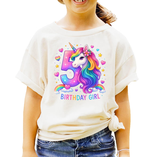 Flat lay of pink girls birthday shirt featuring colorful unicorn and number 5 design