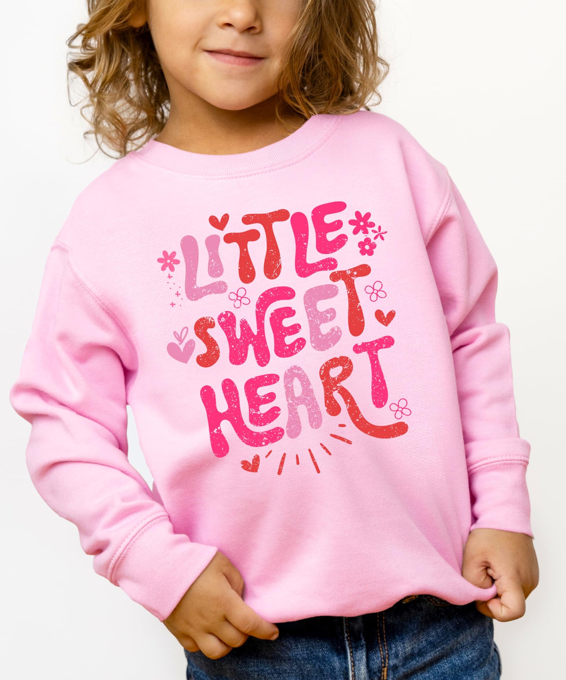Front view of Little Sweet Heart pink sweatshirt for girls on a flat lay background
