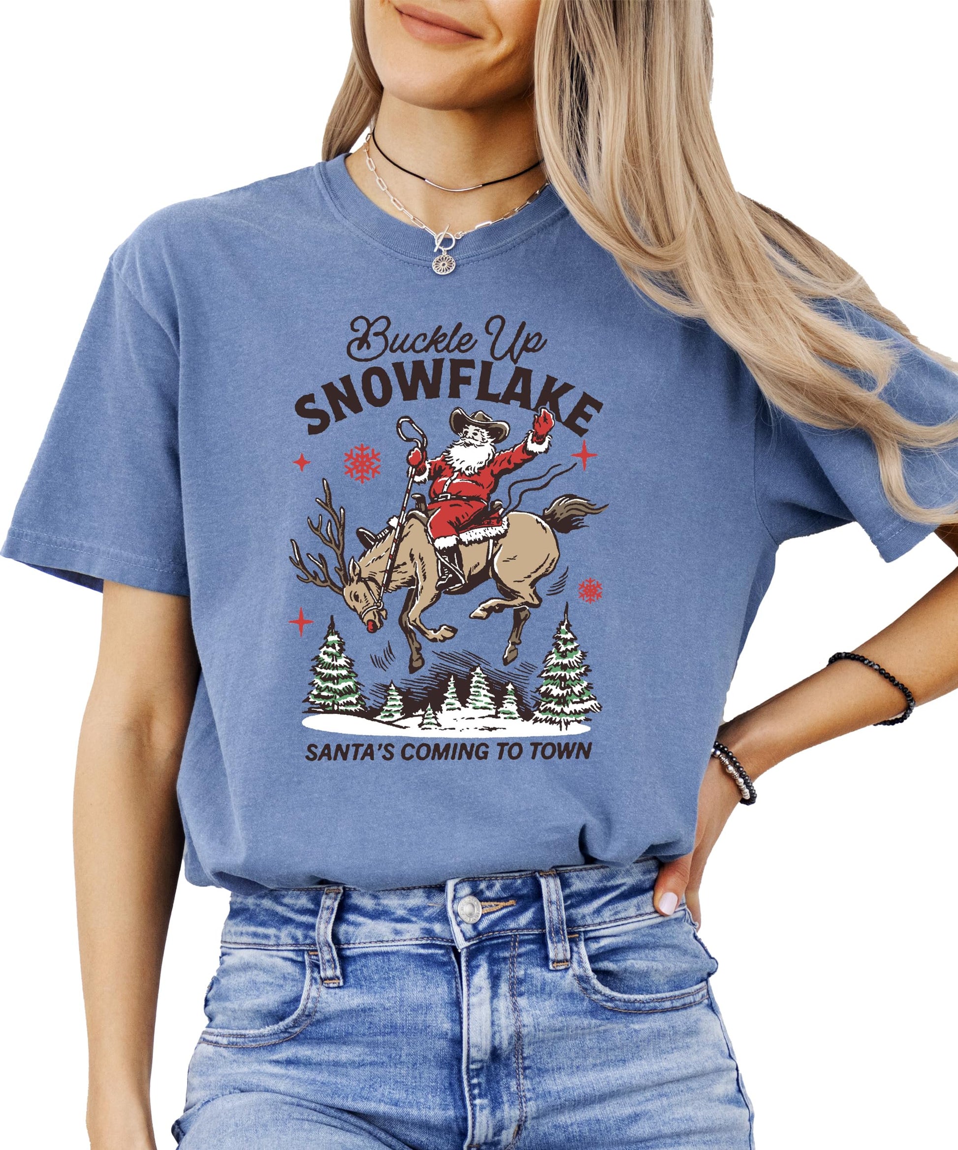 Flat lay of ivory Buckle Up Snowflake Santa's Coming to Town Christmas graphic tee