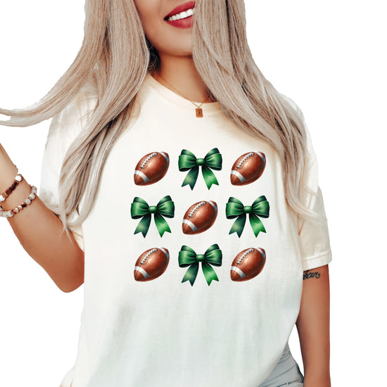 Women's ivory graphic tee with football and green coquette bows design, front view