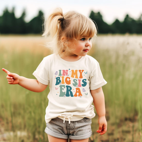 Girl wearing peach In My Big Sis Era graphic tee, perfect for pregnancy announcement or big sister gift