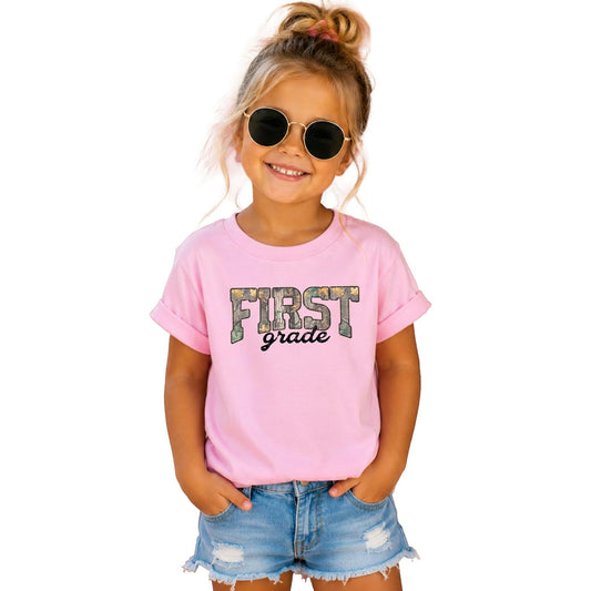 First Grade camo shirts in multiple colors — natural, pink, and military green kids tees