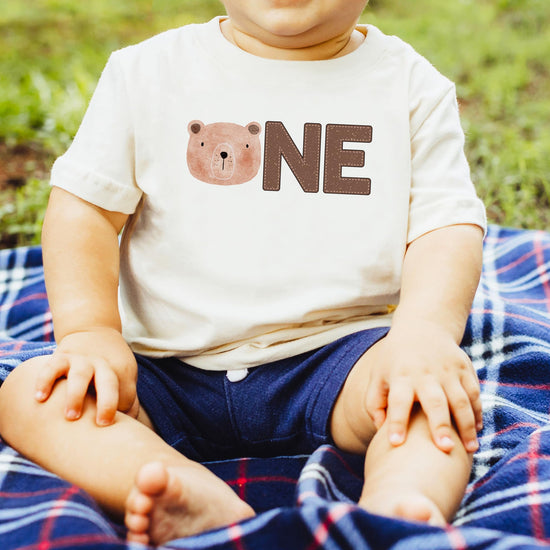 Side view of soft natural first birthday bear graphic tee for boys