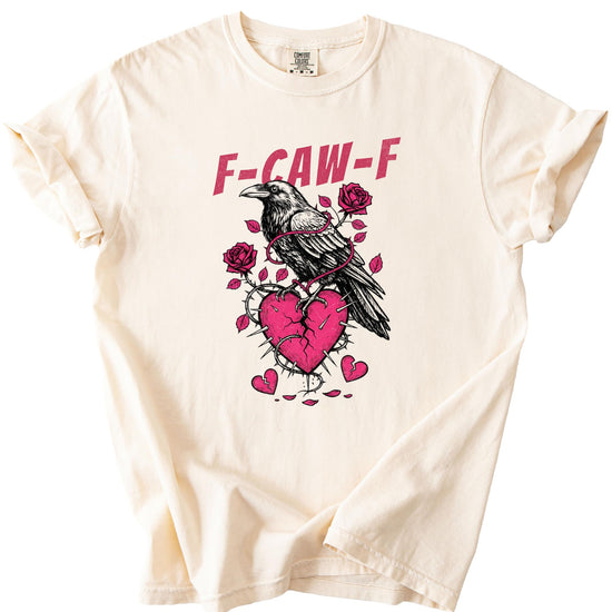 Flat lay of Olive Loves Apple ivory graphic tee with crow and broken heart Valentine's Day design