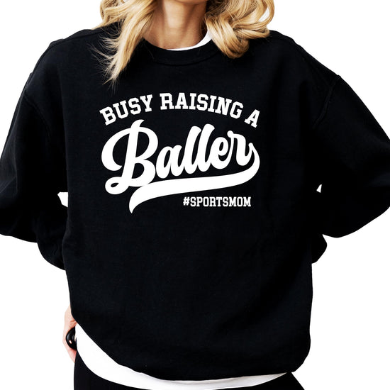 Detail shot of Busy Raising a Baller sweatshirt print quality on black fleece fabric