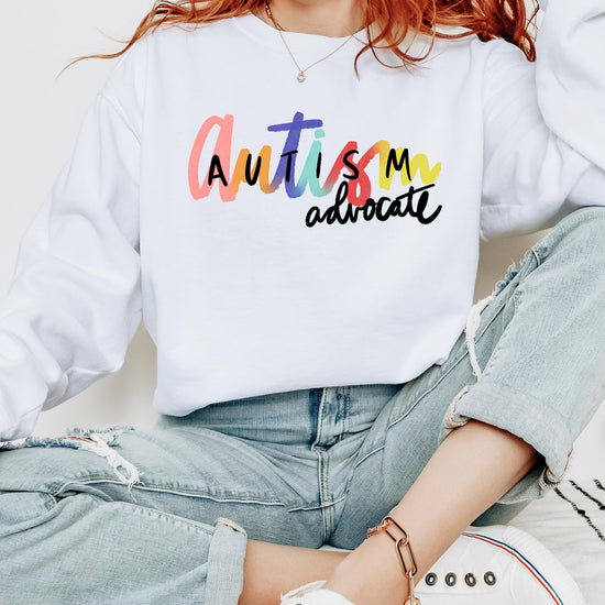 Detail shot of soft white pullover sweatshirt with bold autism awareness graphic by Olive Loves Apple