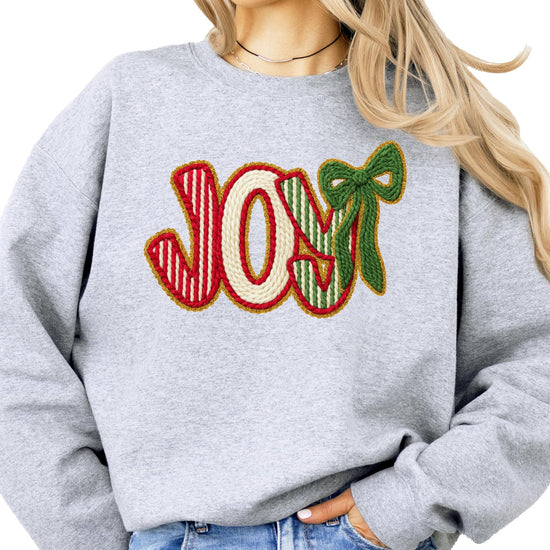 Front view of women's Christmas pullover sweatshirt with JOY graphic in holiday red and green