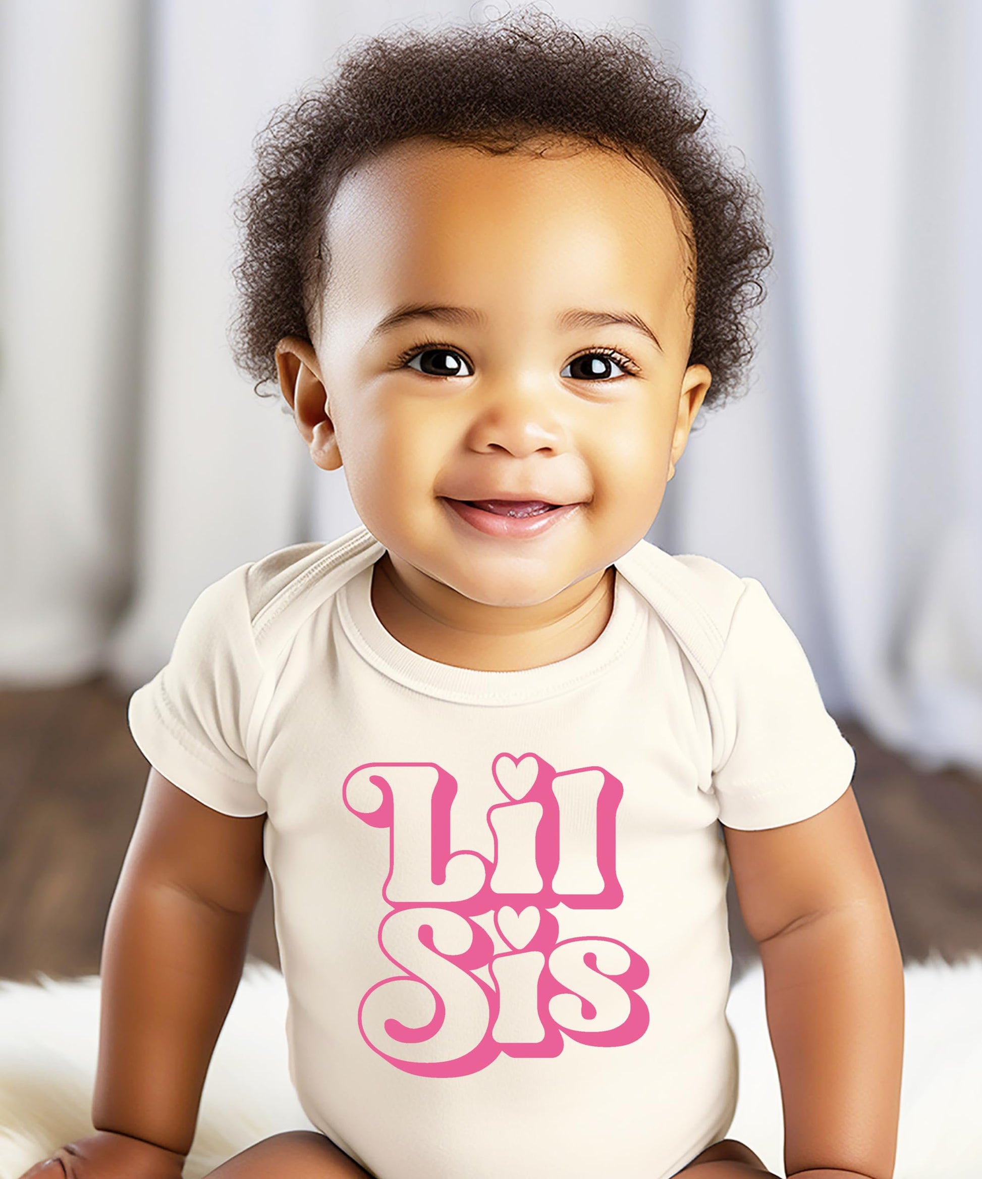 Flat lay of Lil Sis baby girl snap bodysuit with girly retro lettering on natural fabric