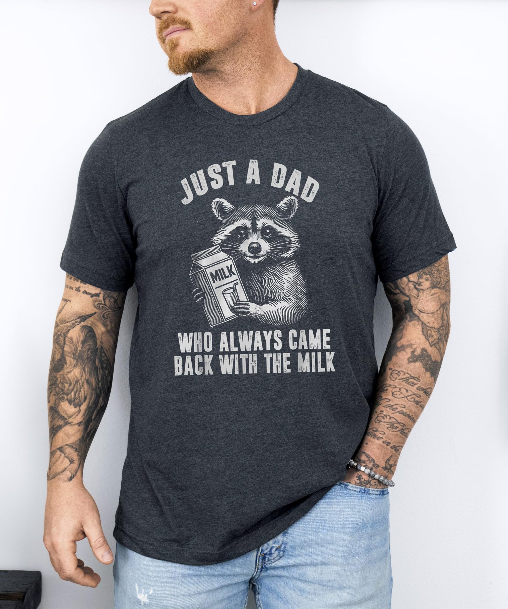 Flat lay of men's dark gray graphic tee with humorous raccoon dad design
