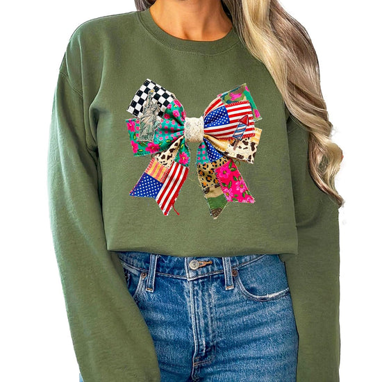 Detail shot of ink-printed bow design on white fleece sweatshirt highlighting stars, stripes, and floral Americana elements