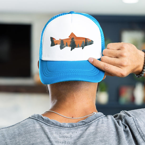Man wearing trout fishing sunset trucker hat - neon blue snapback back view