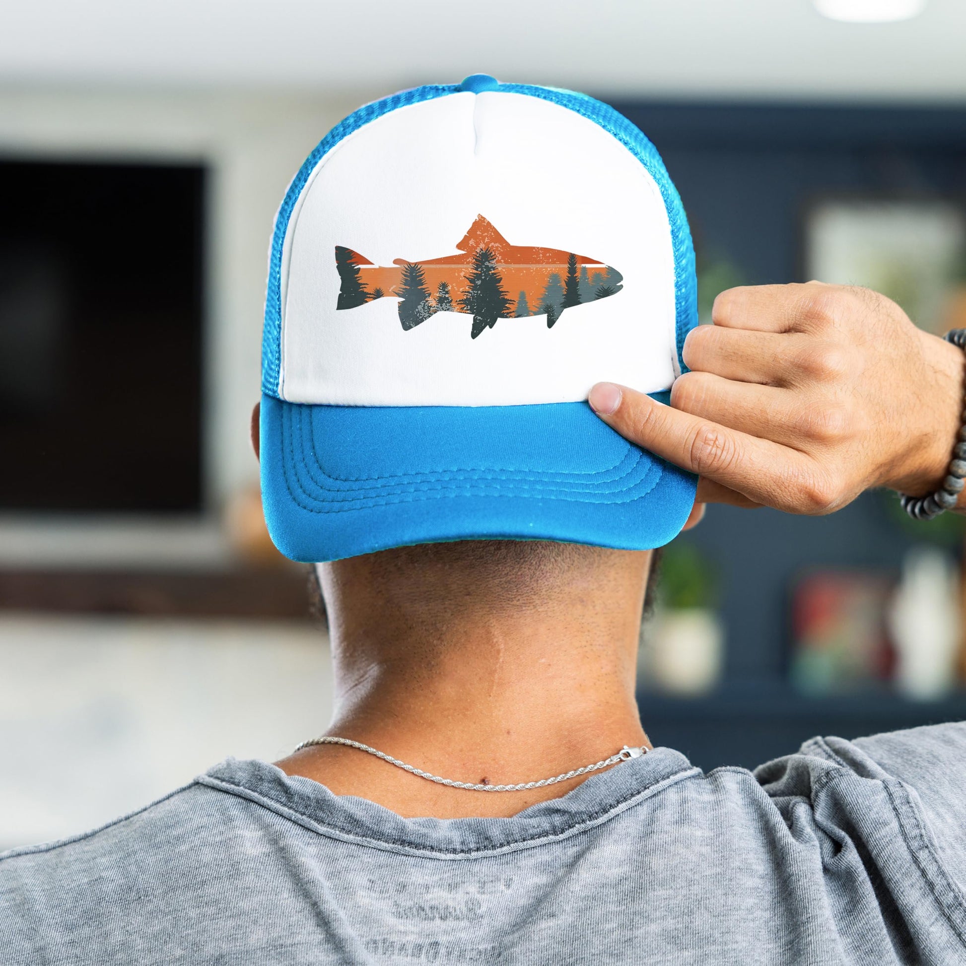 Man wearing trout fishing sunset trucker hat - neon blue snapback back view