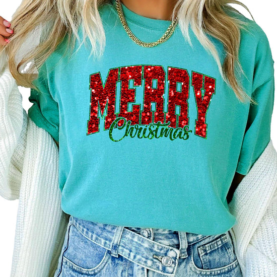 Flat lay of seafoam Merry Christmas faux glitter tee showing full graphic design