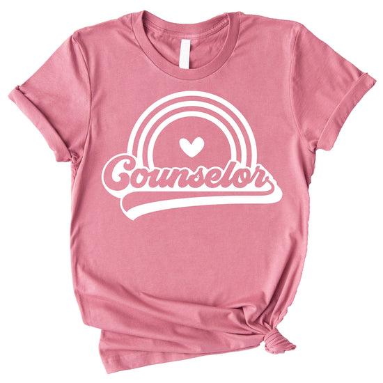 Close-up of retro rainbow counselor shirt print, vibrant colorful graphic on peach tee