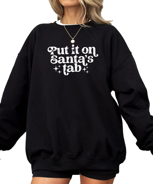 Front view of red holiday graphic sweatshirt with 'Put It on Santa's Tab' humorous Christmas design