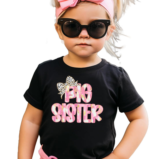 Close-up of Big Sister leopard bow print on black kids graphic tee