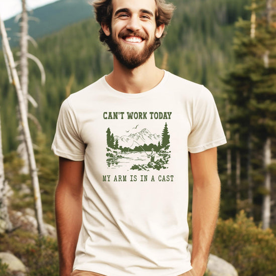 Close-up of 'Can't Work Today My Arm is in a Cast' funny fishing design printed on natural cotton tee