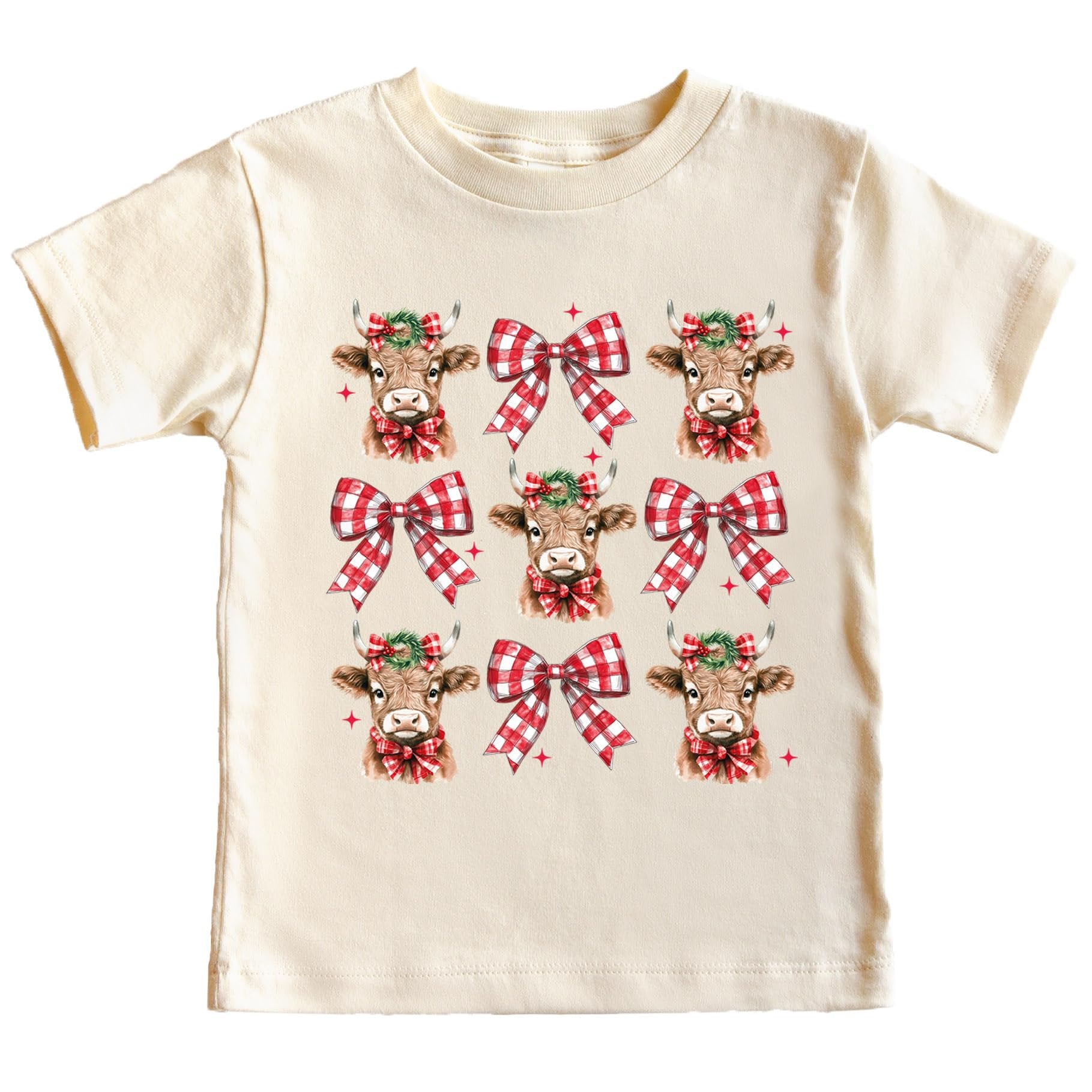 Women's peach Christmas tee featuring a holiday cow with a wreath and red plaid bows graphic